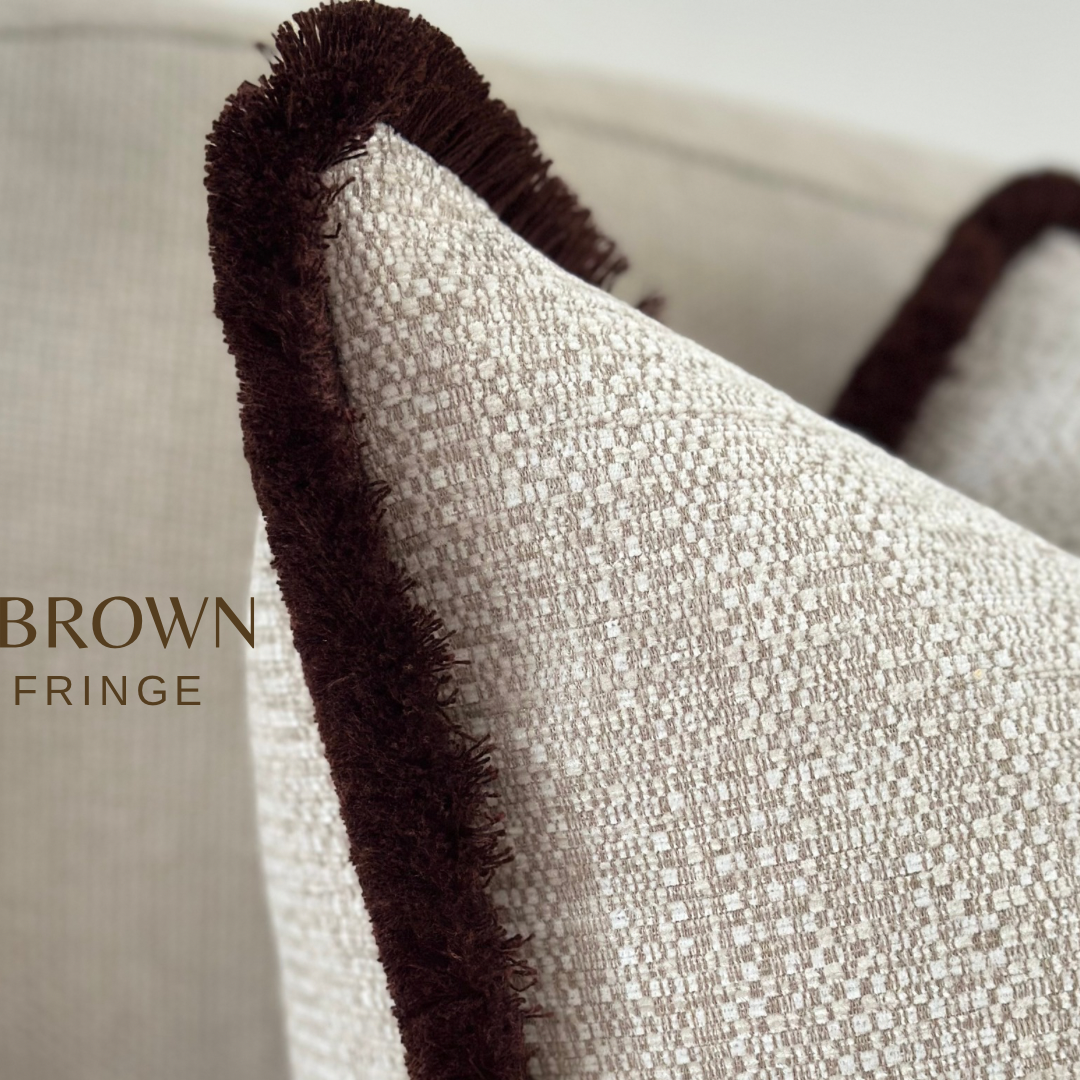 Luxury fringed cushion that is textured and beige and ivory in colour.