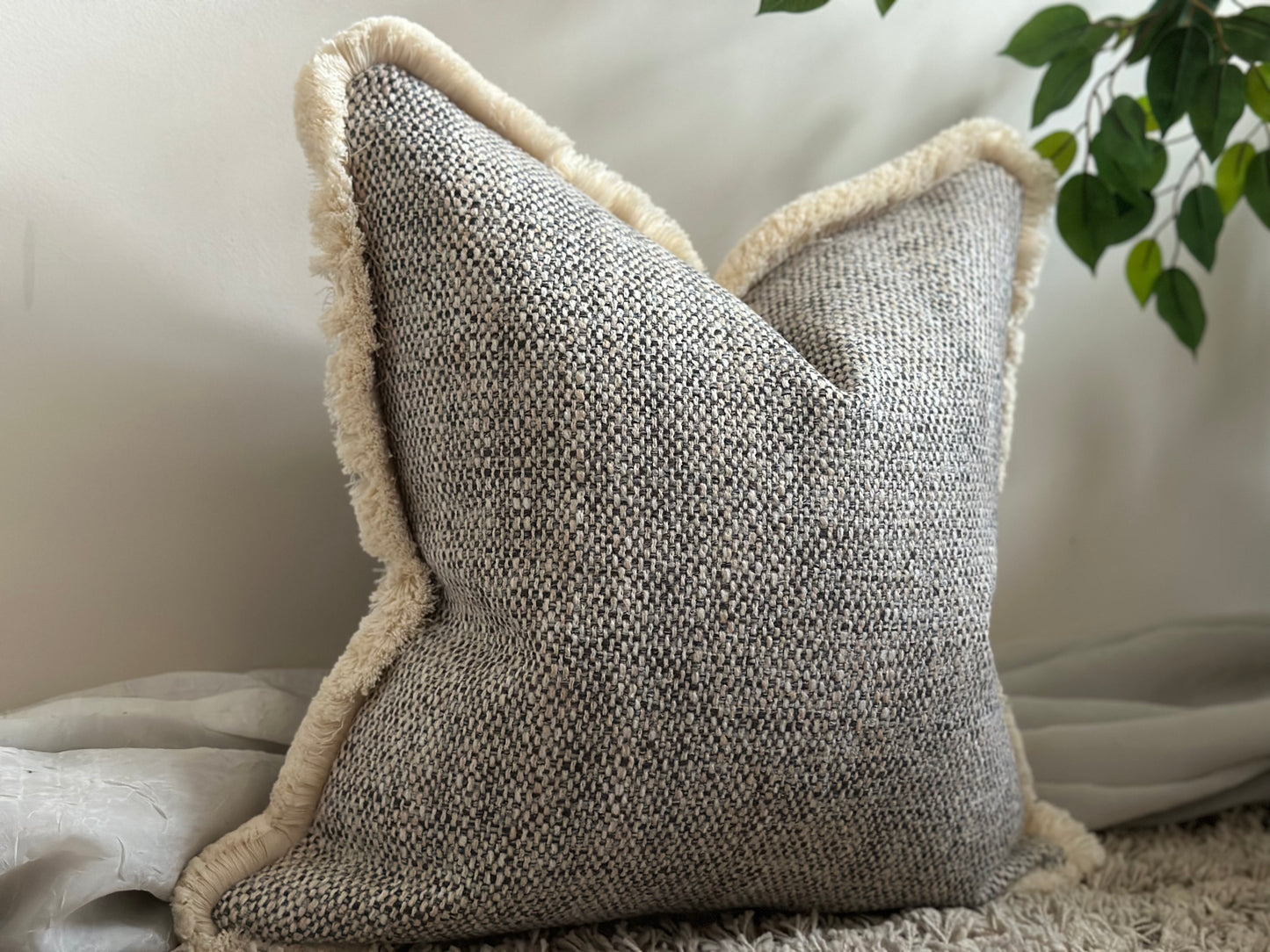 Textured grey fringed pillow