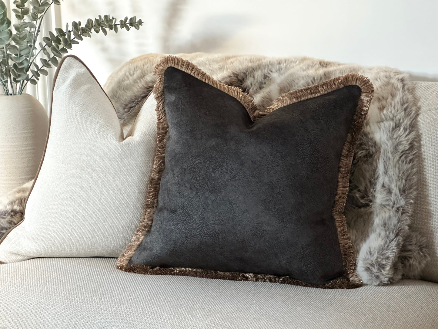 A blend of rich black textured fabric and fringe trim, the Cushion adds depth and luxury to any space, perfect for modern, transitional, and cosy interiors.