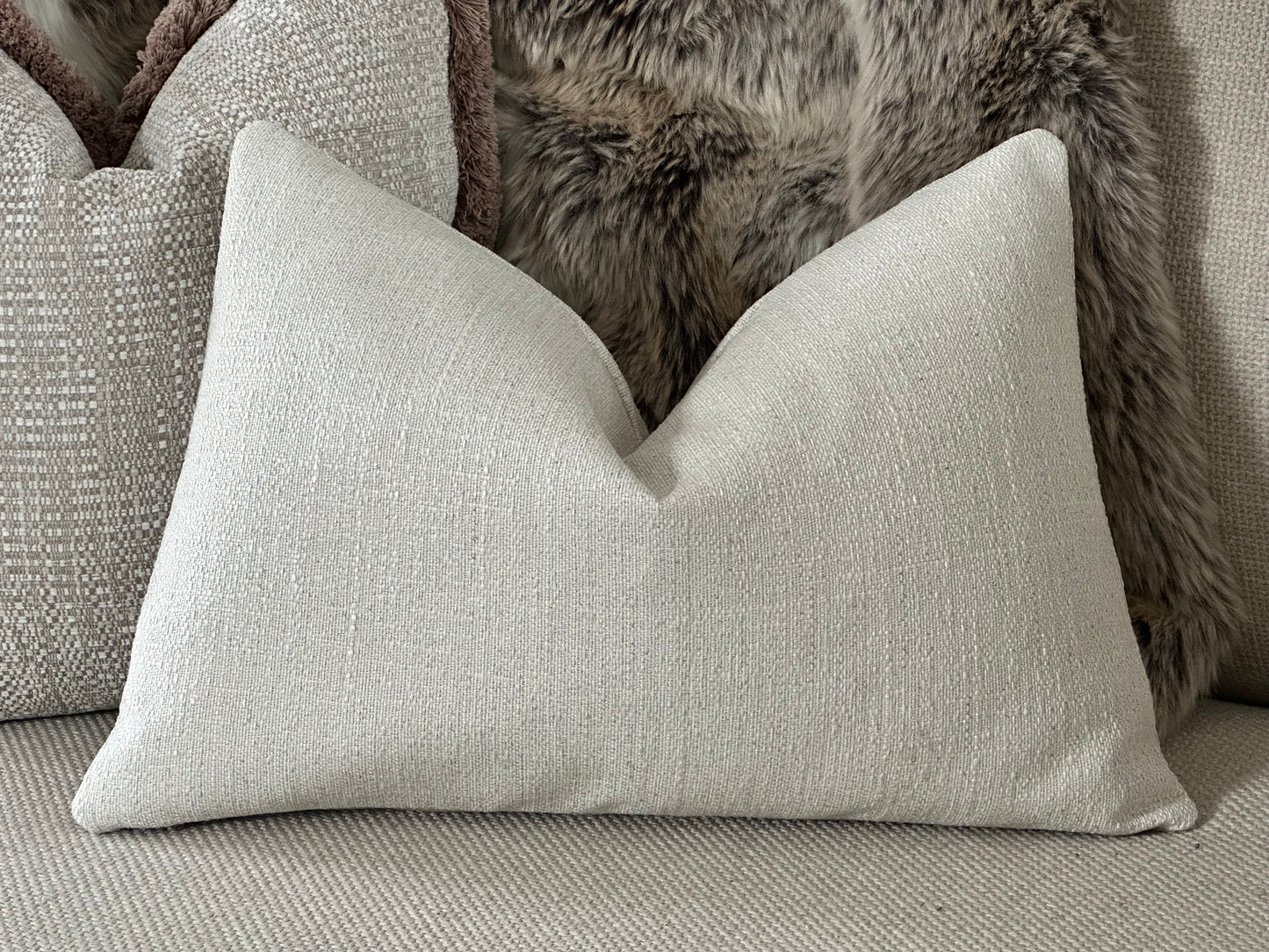 Textured off white lumbar pillow.