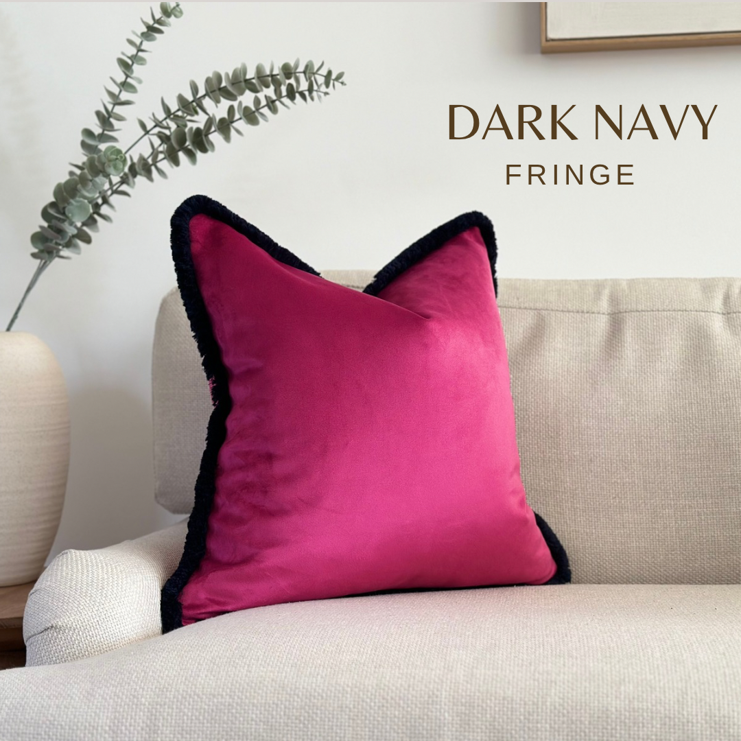 Cerise pink velvet cushion with dark navy fringe.