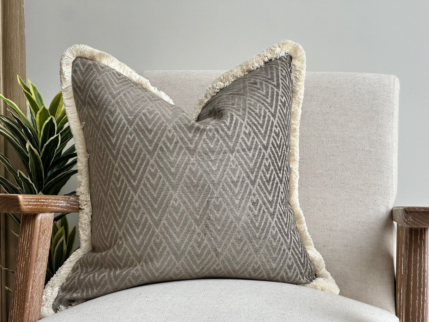 Luxury geometric grey cushion with fringe.