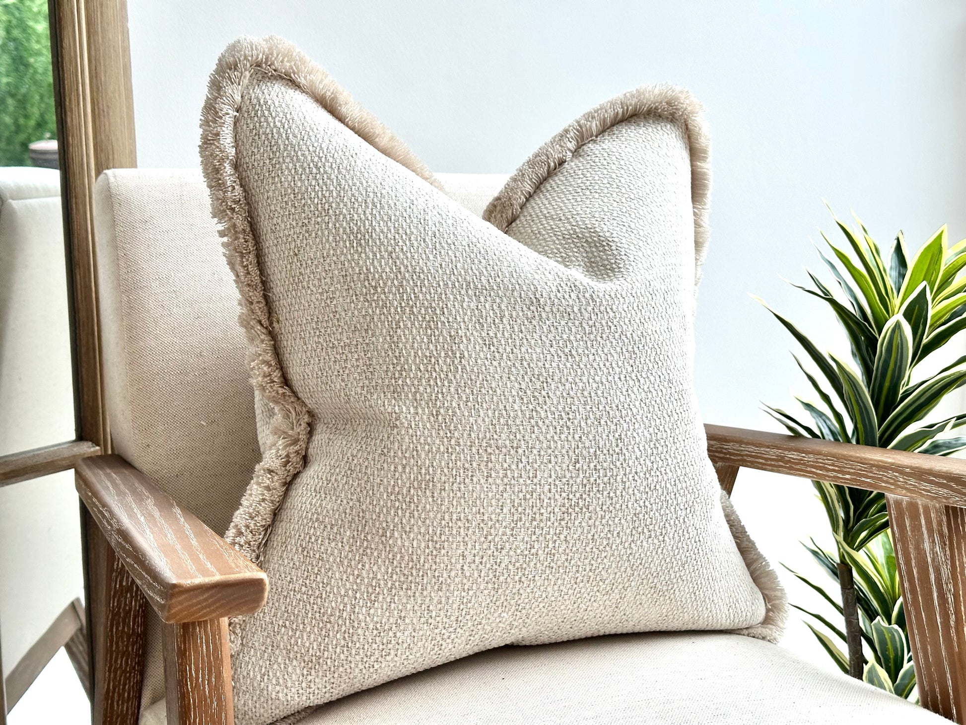 Textured cream ivory textured cushion with a luxury bone coloured fringe fluffy boarder