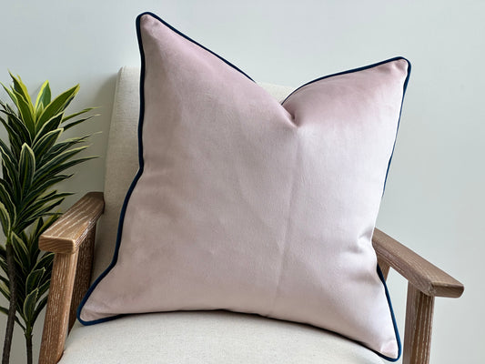 Blush pink pillow with blue piping.