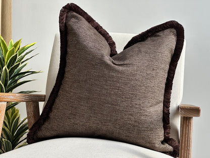 Brown pillow with fluffy fringe trim