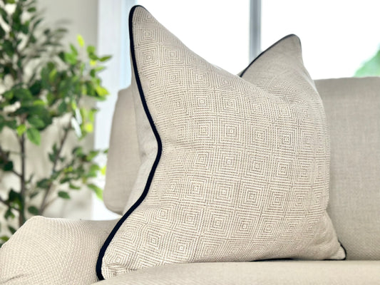 Textured neutral Geometric cushion with black piped edge