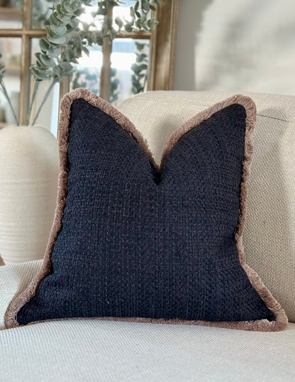 Luxurious bespoke cushion with a black textured fabric and beige fringe trim, elegantly styled on a neutral-toned sofa. Designed for sophistication and comfort, perfect for elevating any interior space