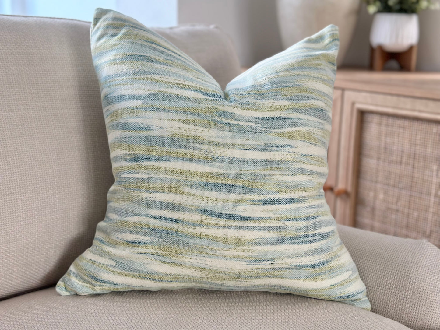 Costal sea side style cushion with relaxing blue and green tones with an ikat pattern.