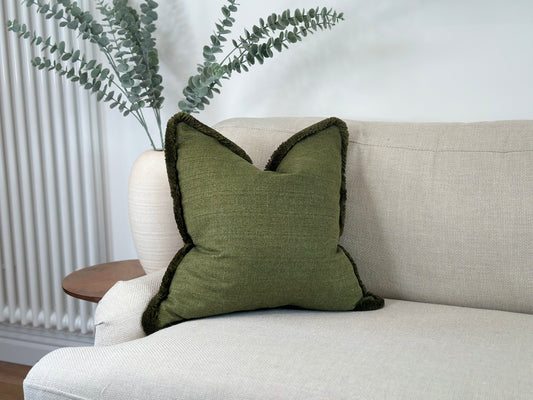 Earthy green cushion with fringe perfect for a modern organic decor.