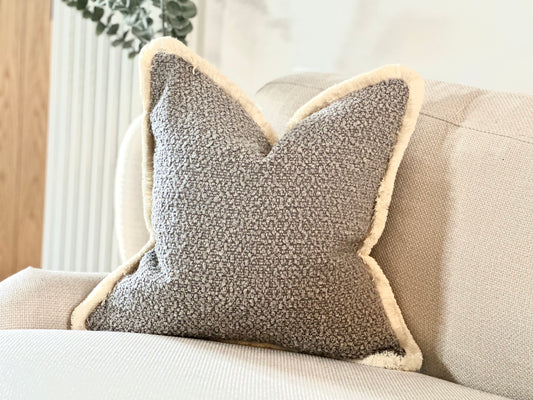 A Luxury textured grey boucle cushion with cream fringe, custom made In small, medium and large sizes.