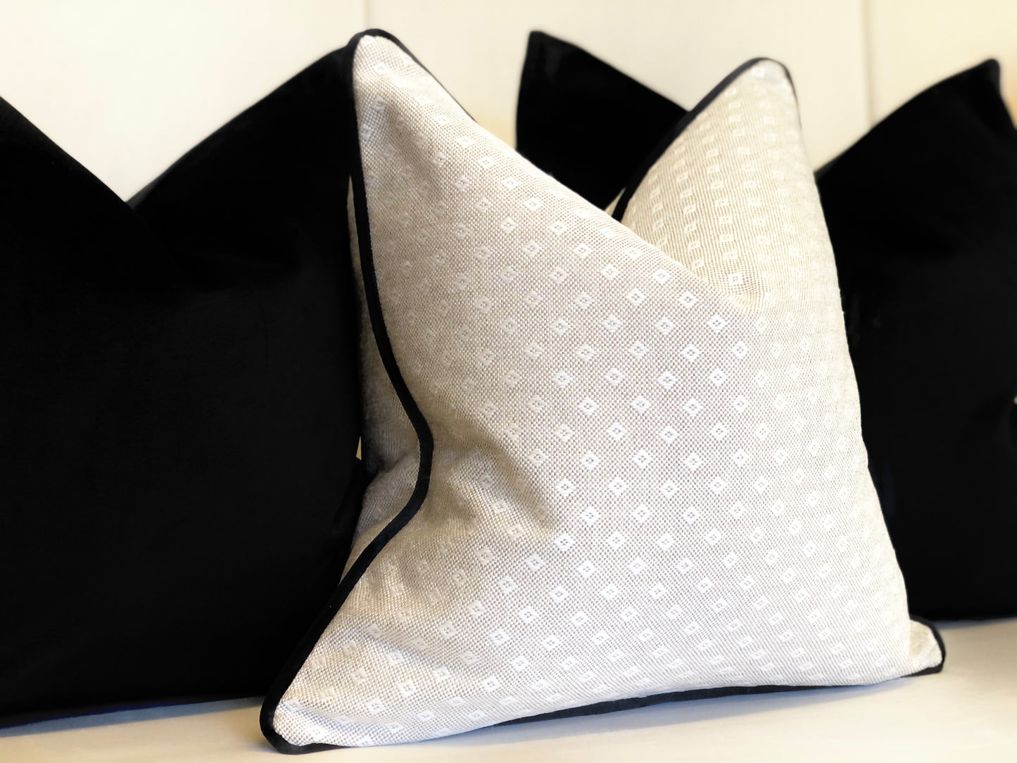 beige pillow with black trim