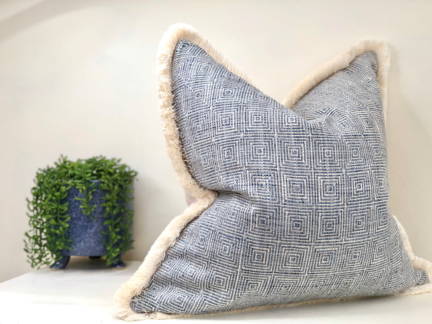 blue patterned cushion with fringe