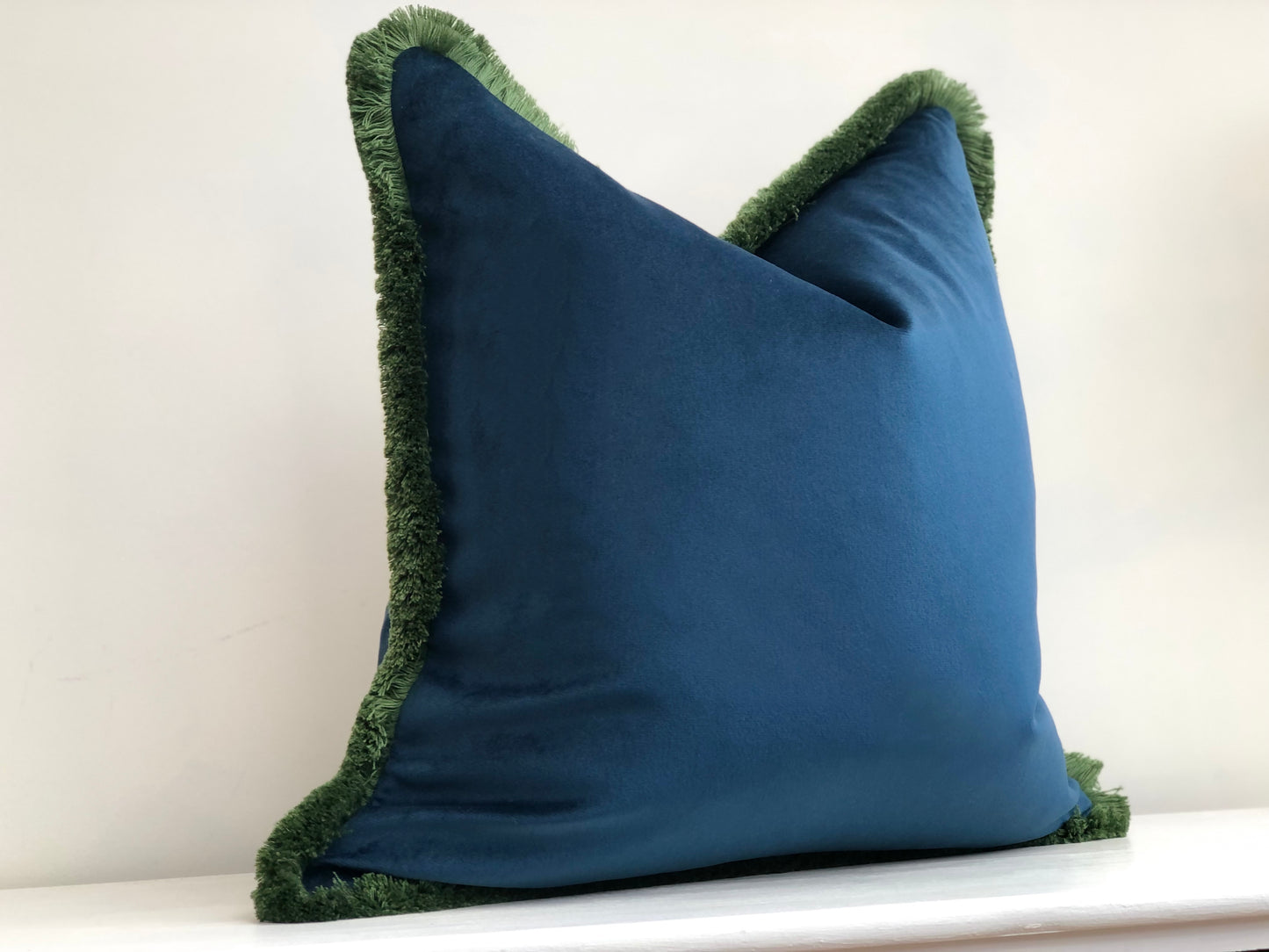 blue cushion with green fringe