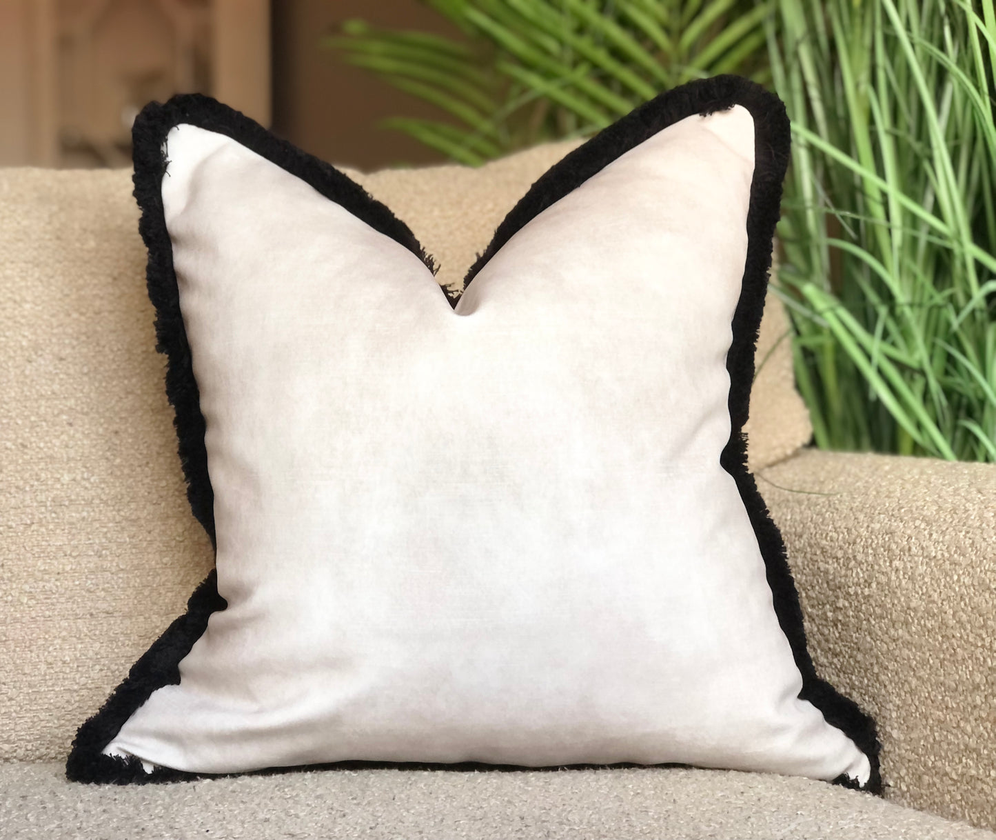 white cushion with black fluffy trim